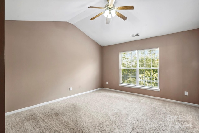 carpeted spare room with ceiling fan and vaulted ceiling