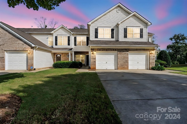 front facade with a yard and a garage