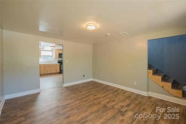 unfurnished room featuring dark hardwood / wood-style flooring and sink