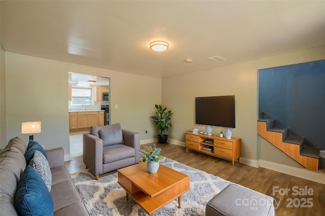 living room featuring hardwood / wood-style flooring and sink