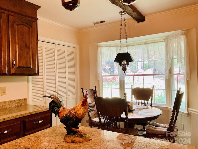 dining room featuring beam ceiling, ornamental molding, and a wealth of natural light