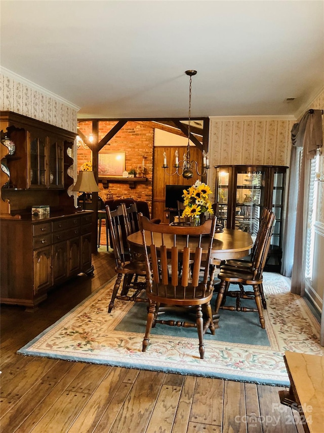 dining space featuring dark hardwood / wood-style flooring, lofted ceiling, crown molding, and a chandelier