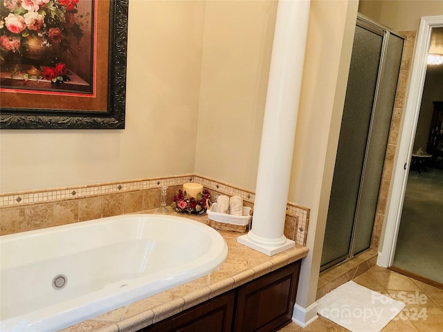 bathroom with separate shower and tub, tile patterned floors, and decorative columns