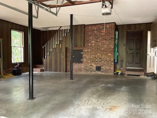 garage with wooden walls and a garage door opener