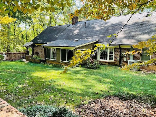 back of house featuring a lawn and central AC