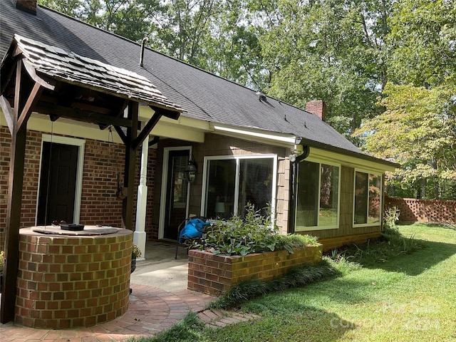 rear view of house featuring a lawn and a patio