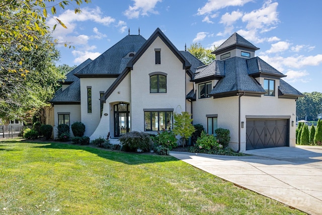 french country style house with a garage and a front yard