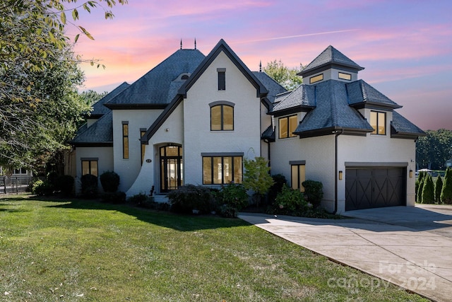 french country inspired facade with a lawn and a garage