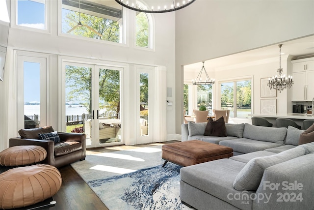 living room featuring a water view, french doors, a healthy amount of sunlight, and wood-type flooring