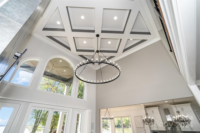 interior details with coffered ceiling, french doors, ornamental molding, and beam ceiling