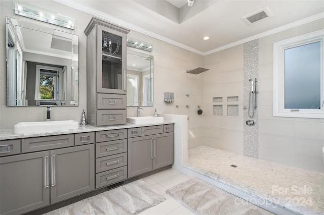 bathroom with vanity, tile patterned flooring, tiled shower, and crown molding