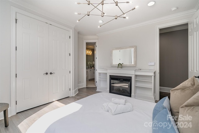 bedroom featuring a closet, crown molding, and light hardwood / wood-style flooring