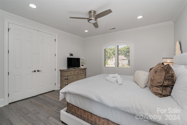 bedroom featuring ornamental molding, a closet, hardwood / wood-style flooring, and ceiling fan