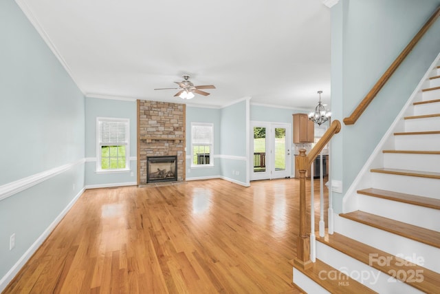 unfurnished living room featuring ornamental molding, plenty of natural light, a fireplace, and light hardwood / wood-style flooring