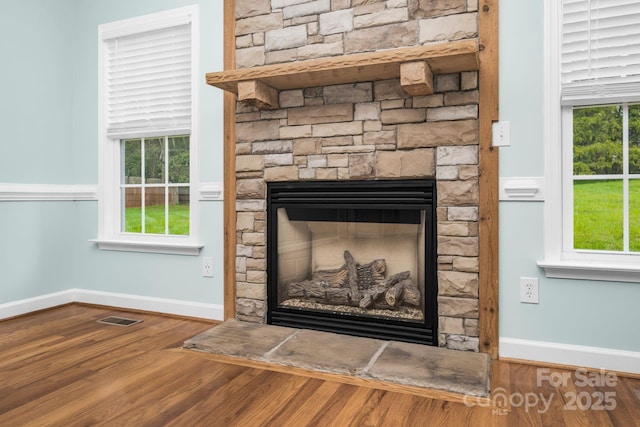 room details featuring hardwood / wood-style flooring and a stone fireplace