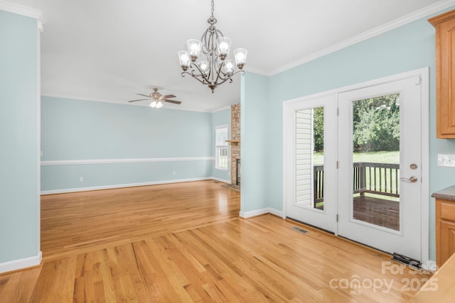 interior space with a brick fireplace, crown molding, ceiling fan with notable chandelier, and light hardwood / wood-style floors