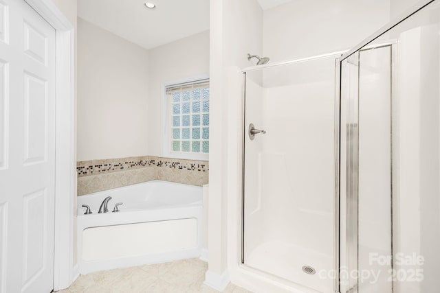 bathroom featuring shower with separate bathtub