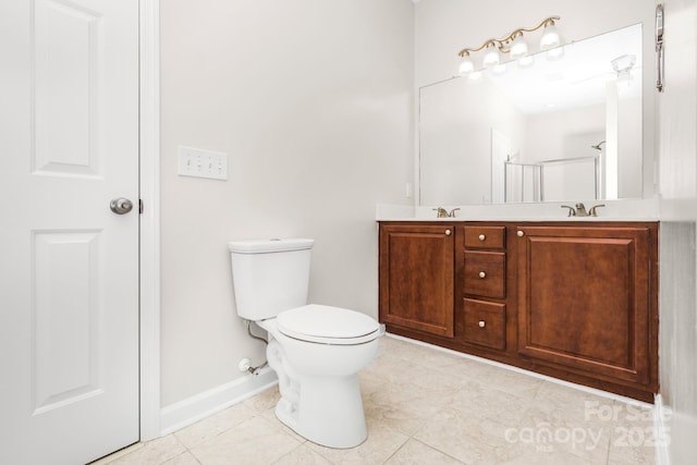 bathroom featuring tile patterned floors, vanity, toilet, and a shower with shower door