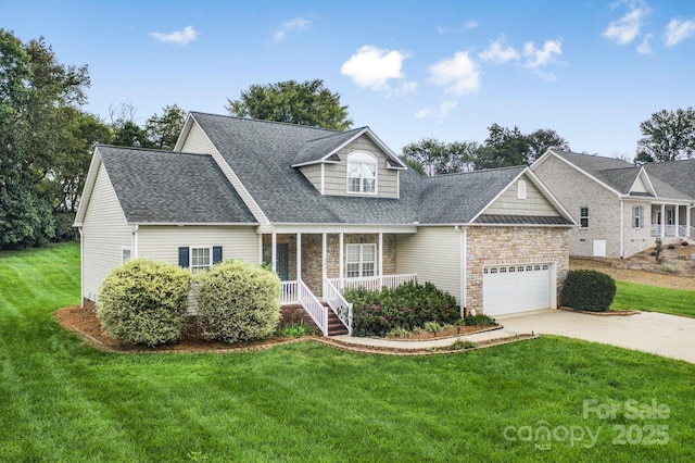 view of front of property featuring a garage, a front yard, and covered porch