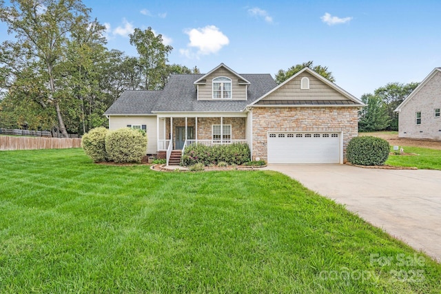 view of front of home with a garage, a front lawn, and covered porch