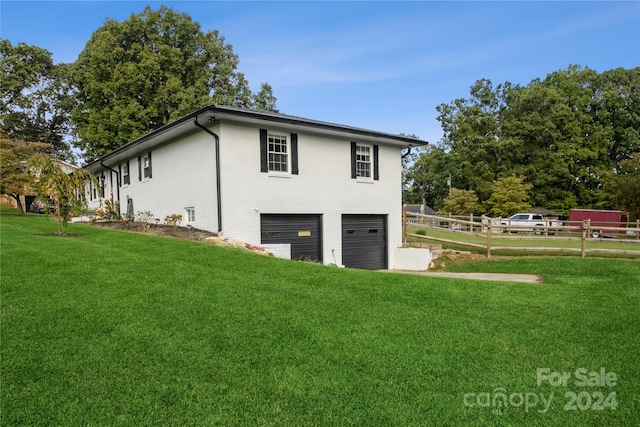 view of side of home featuring a lawn and a garage