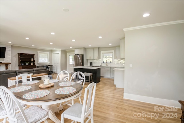 dining area featuring light hardwood / wood-style floors and crown molding