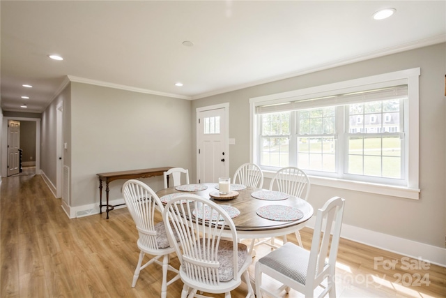 dining room featuring light hardwood / wood-style floors and crown molding