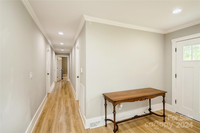 foyer with light wood-type flooring and ornamental molding