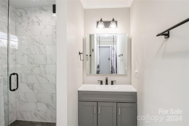 bathroom with vanity, a shower with shower door, and crown molding