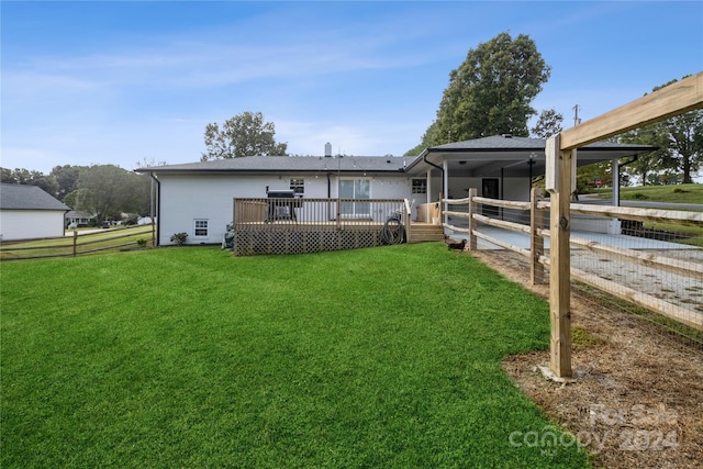 rear view of property with a lawn and a wooden deck