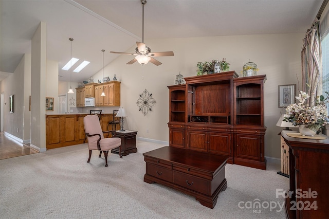 carpeted home office with a skylight, high vaulted ceiling, and ceiling fan