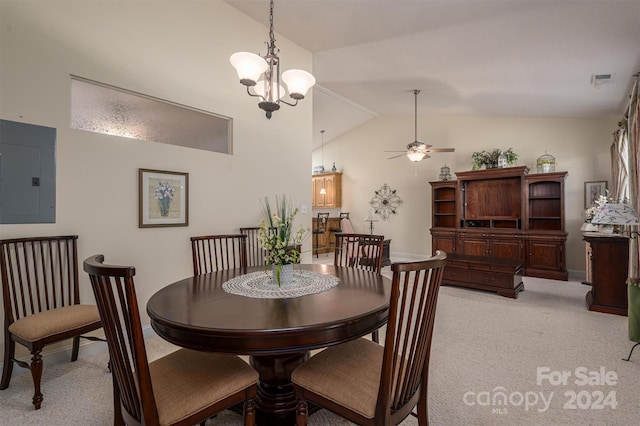 dining area featuring ceiling fan with notable chandelier, electric panel, vaulted ceiling, and light colored carpet