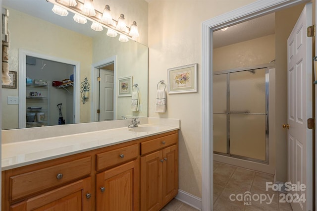 bathroom with vanity, tile patterned flooring, and an enclosed shower