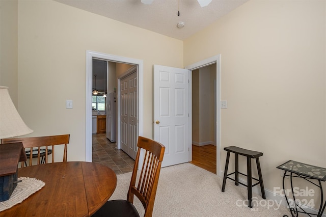 dining room featuring ceiling fan, a textured ceiling, and carpet