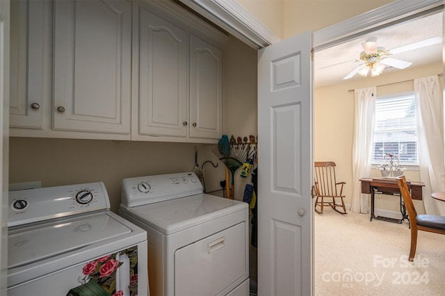 clothes washing area featuring ceiling fan, light colored carpet, cabinets, and washing machine and dryer