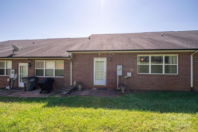 back of house with a lawn and a patio