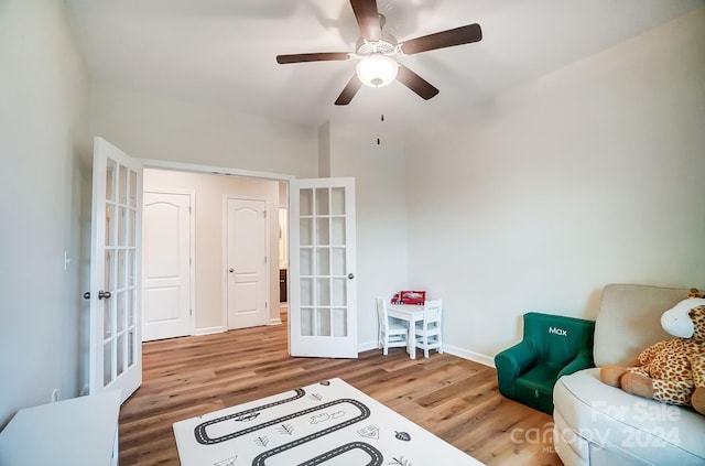 living area with french doors, ceiling fan, and hardwood / wood-style floors