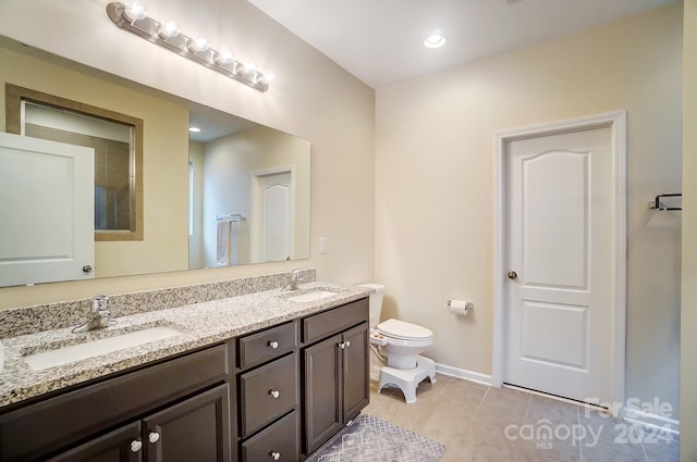 bathroom with tile patterned floors, vanity, and toilet