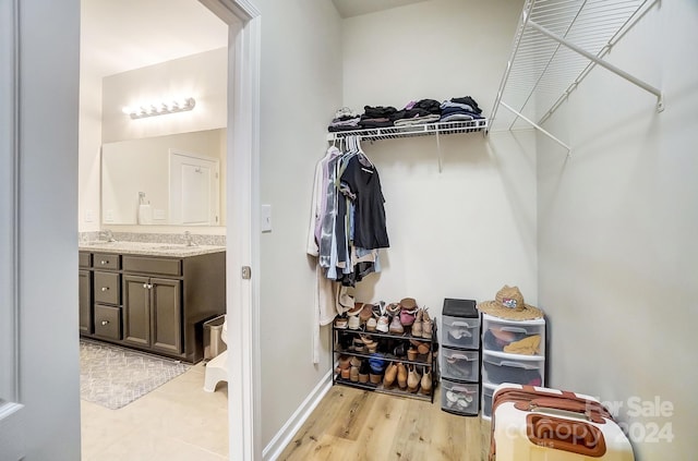 walk in closet with light hardwood / wood-style flooring and sink