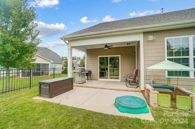 rear view of house featuring ceiling fan, a yard, and a patio area