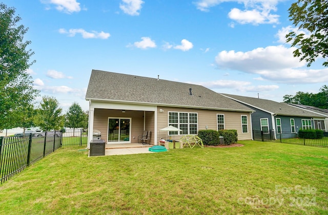 rear view of house featuring a lawn and a patio area