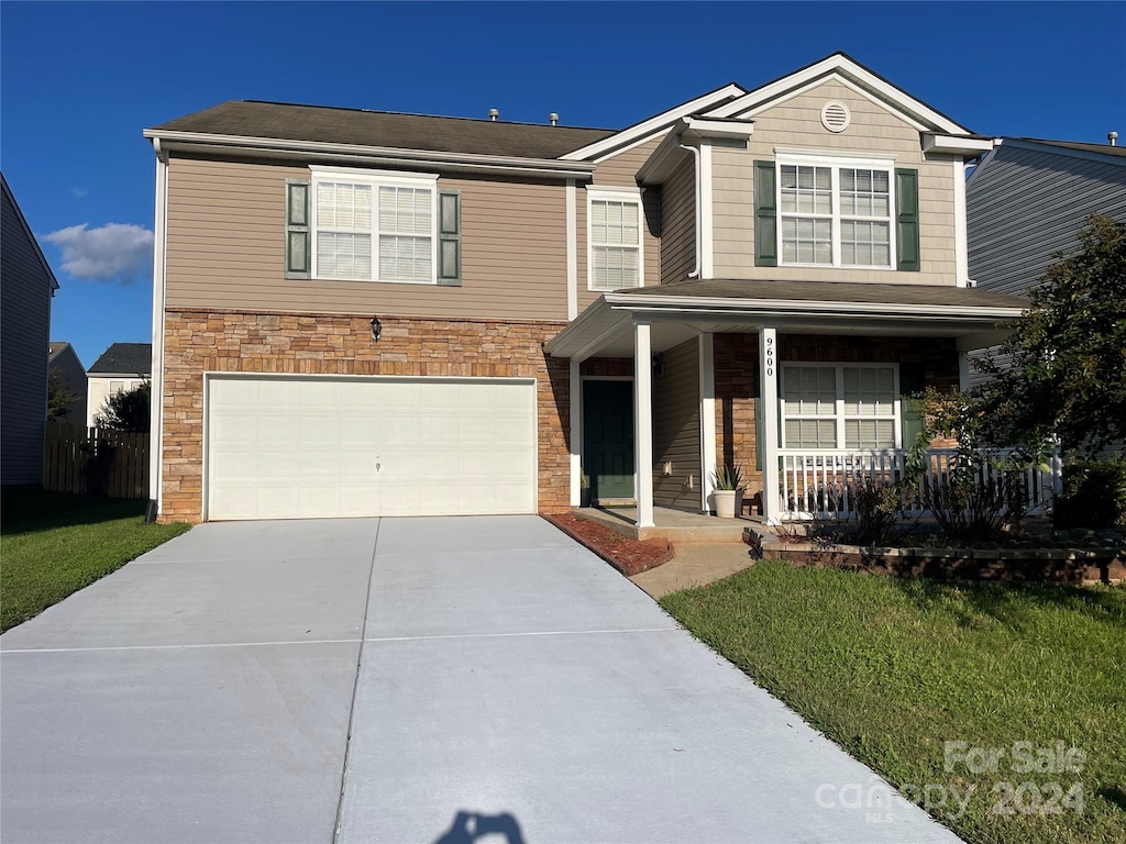 view of property with a front yard, a porch, and a garage