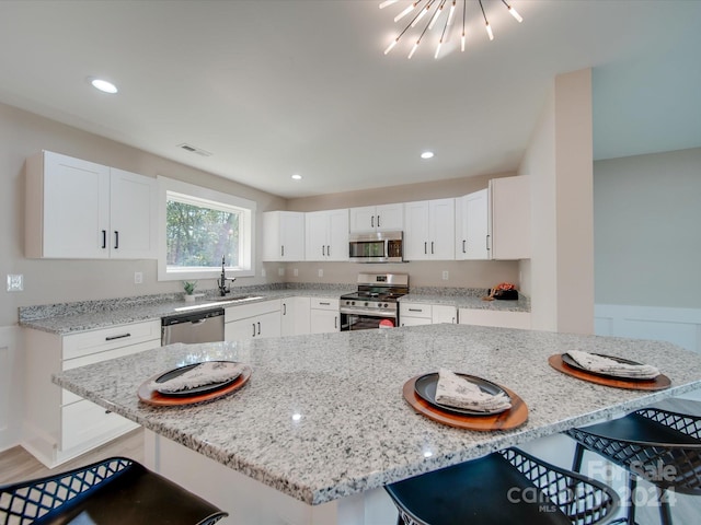 40 Ridgecrest Ave, Peachland, NC 28133 - kitchen featuring appliances with stainless steel finishes, a breakfast bar area, white cabinetry, light stone countertops, and recessed lighting