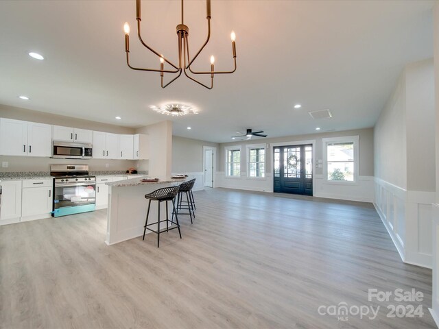40 Ridgecrest Ave, Peachland, NC 28133 - kitchen featuring appliances with stainless steel finishes, open floor plan, a chandelier, a wainscoted wall, and white cabinets