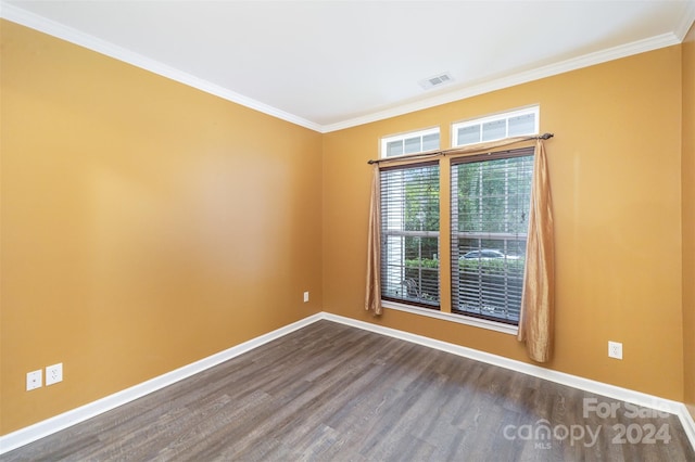 empty room featuring hardwood / wood-style floors and ornamental molding