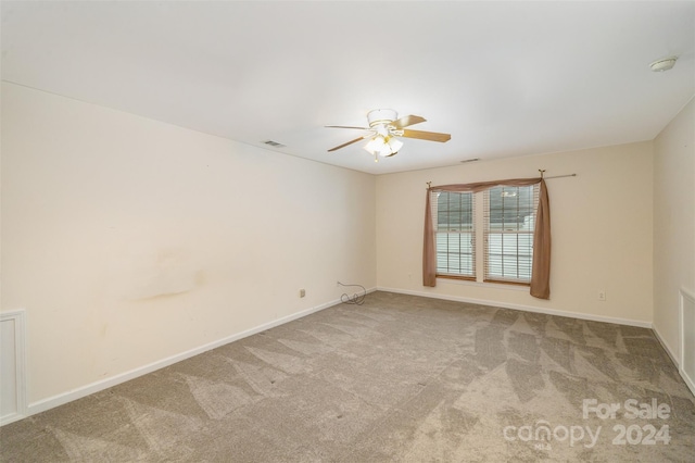 carpeted spare room with ceiling fan