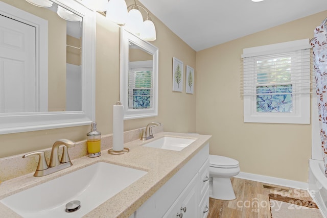 full bathroom with vanity, hardwood / wood-style floors, toilet, and shower / tub combo with curtain