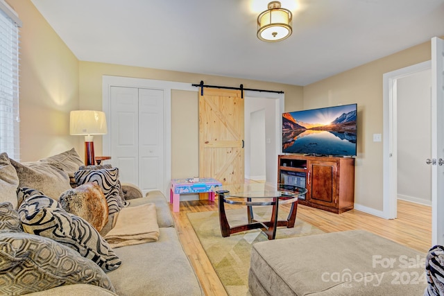 living room featuring light wood-type flooring and a barn door