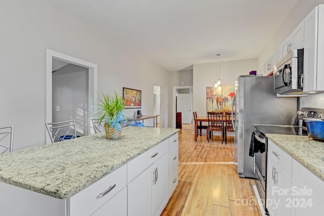 kitchen featuring white cabinets, pendant lighting, a kitchen island, light hardwood / wood-style flooring, and appliances with stainless steel finishes