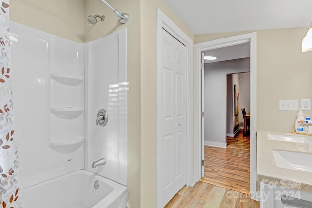 bathroom featuring shower / bathtub combination with curtain, hardwood / wood-style floors, vanity, and vaulted ceiling